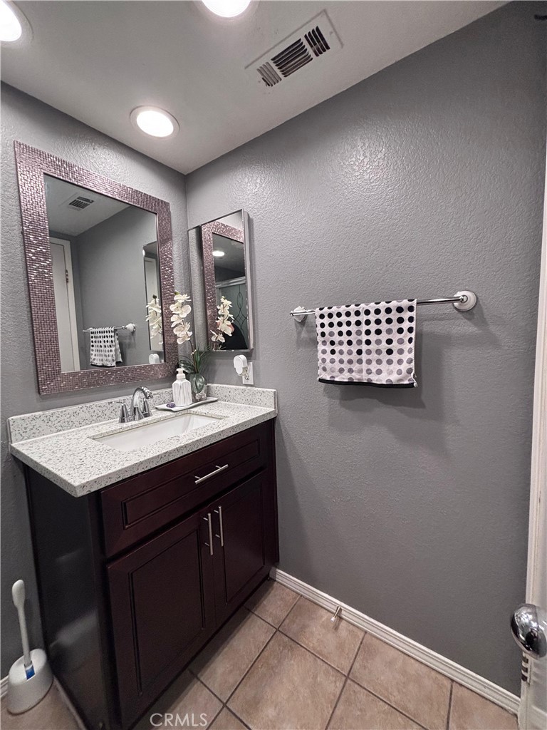 560 Coudures Way Perris, CA 92571 - Photo 20 of 35 a bathroom with a sink a vanity and a mirror