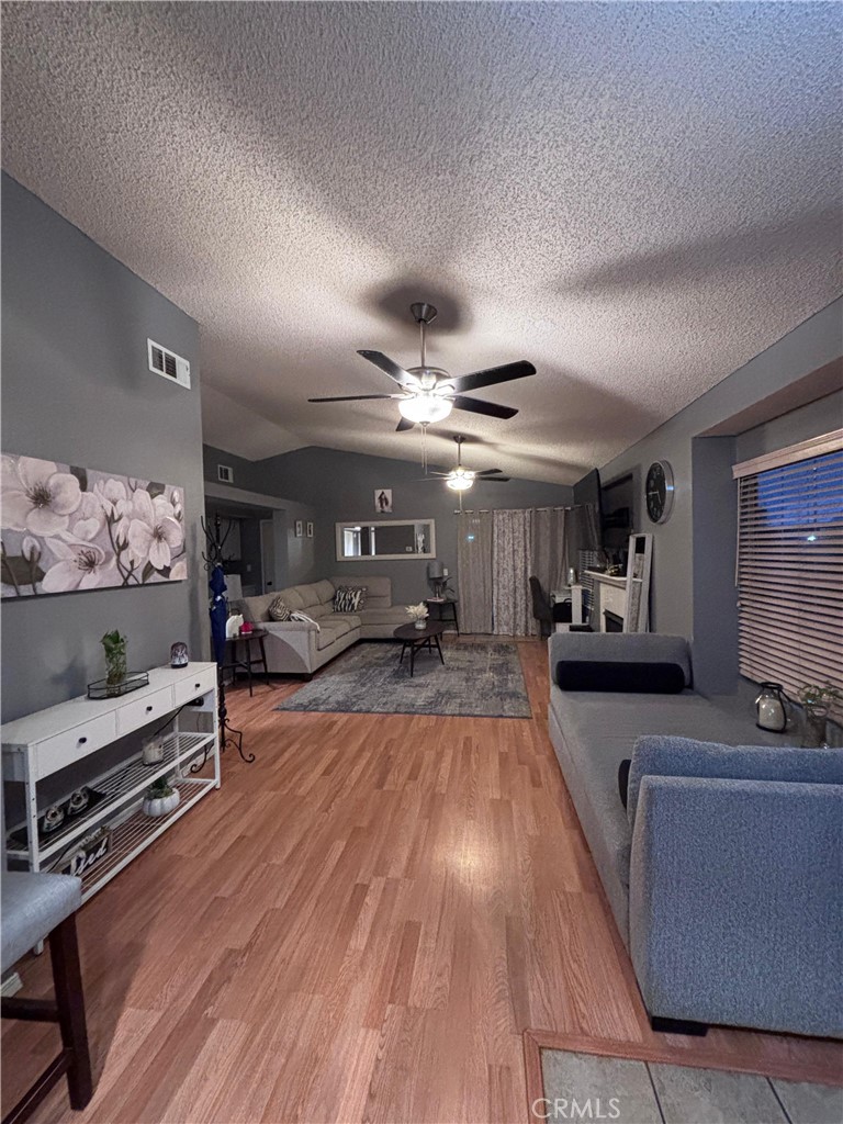 560 Coudures Way Perris, CA 92571 - Photo 24 of 35 a large living room with furniture a flat screen tv and a dresser