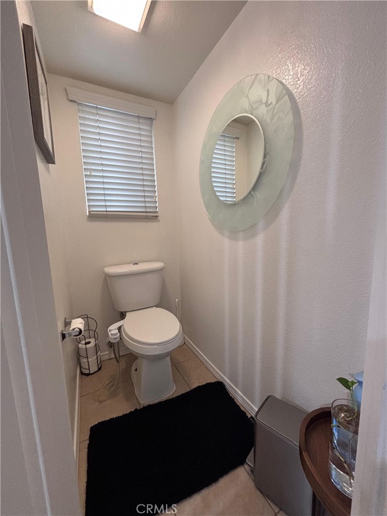 560 Coudures Way Perris, CA 92571 - Photo 6 of 35 a bathroom with a toilet a sink and a mirror