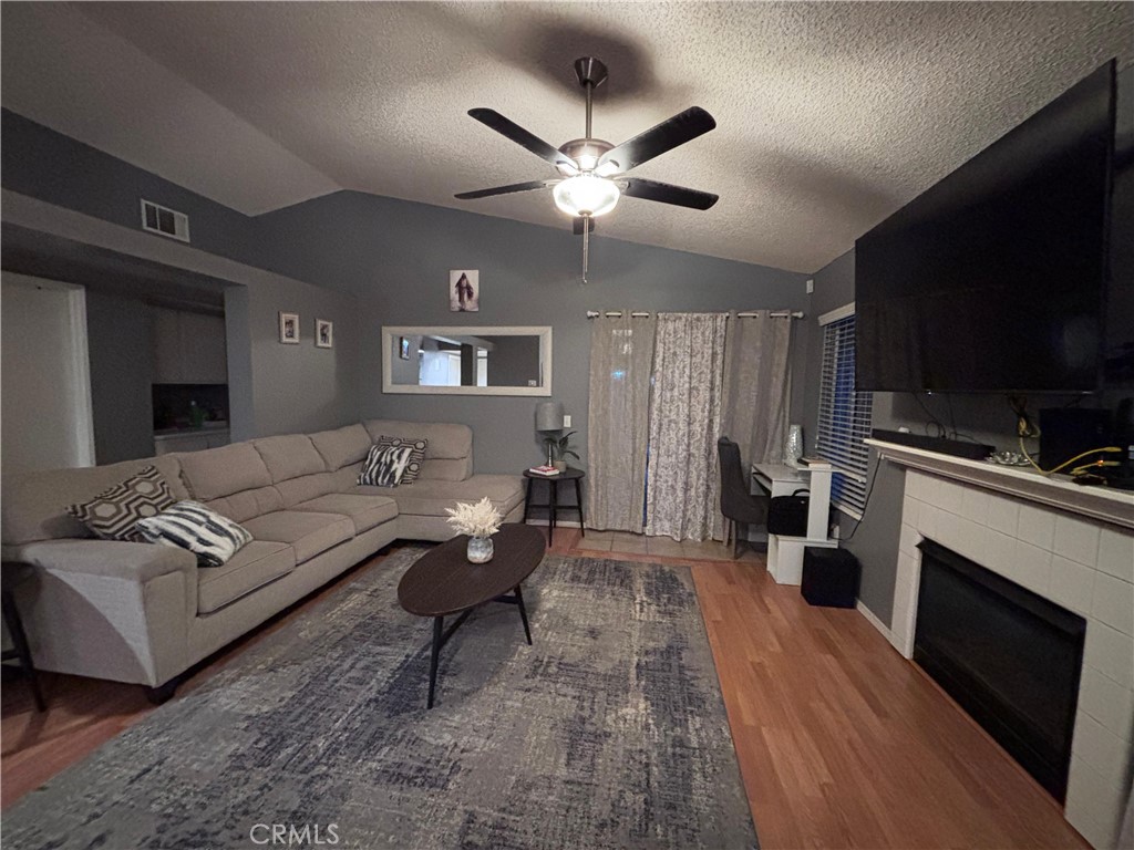 560 Coudures Way Perris, CA 92571 - Photo 9 of 35 a living room with furniture a fireplace and a flat screen tv