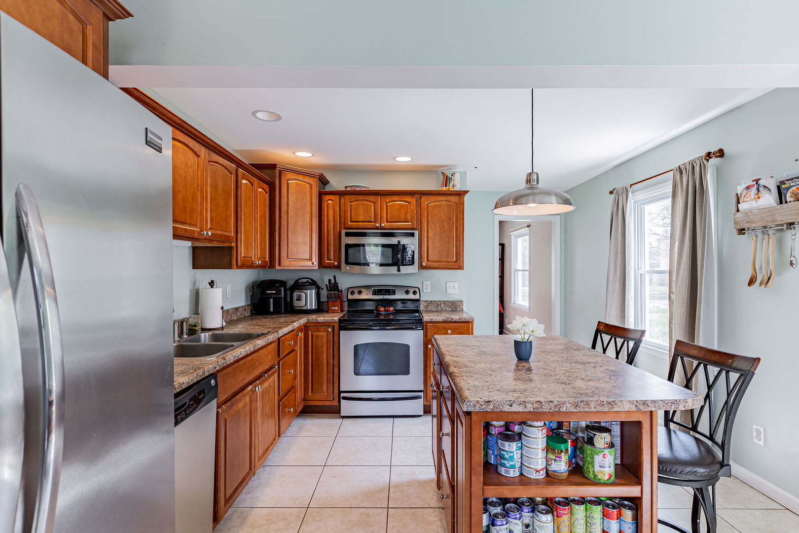 315 South Garfield Avenue Champaign, IL 61821 - Photo 12 of 28 a kitchen with stainless steel appliances granite countertop a stove a refrigerator a sink dishwasher a dining table and chairs with wooden floor