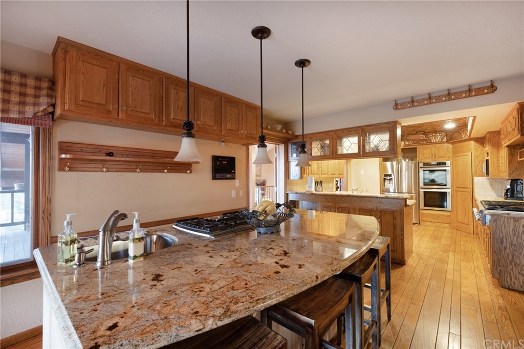 488 Highway 2 Wrightwood, CA 92397 - Photo 23 of 54 a kitchen with stainless steel appliances granite countertop a stove a sink and a wooden cabinets