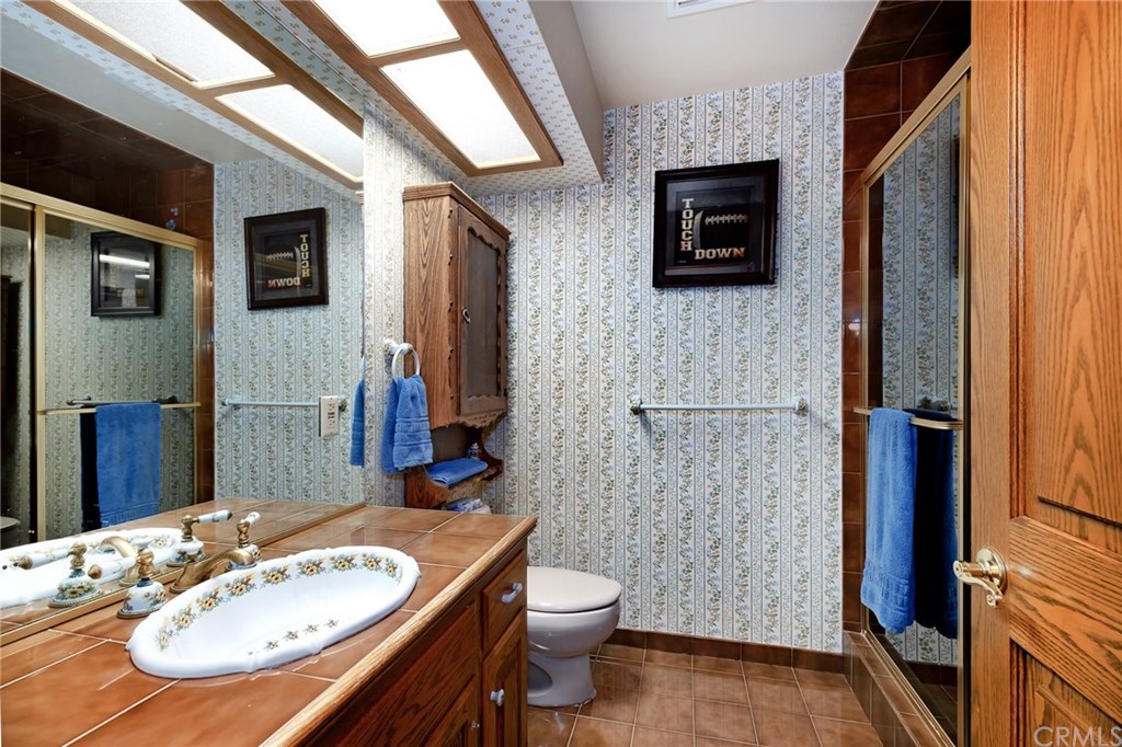 488 Highway 2 Wrightwood, CA 92397 - Photo 46 of 54 a bathroom with a granite countertop sink a toilet a mirror and shower