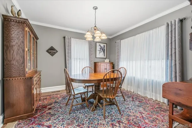 a dining room with furniture window and wooden floor