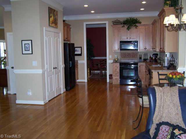 7805 Wilson Farm Road Summerfield, NC 27358 - Photo 3 of 9 Other. This large kitchen has warm, maple cabinetry with black appliances.