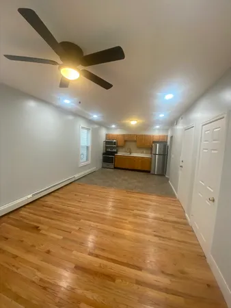 a view of empty room with wooden floor