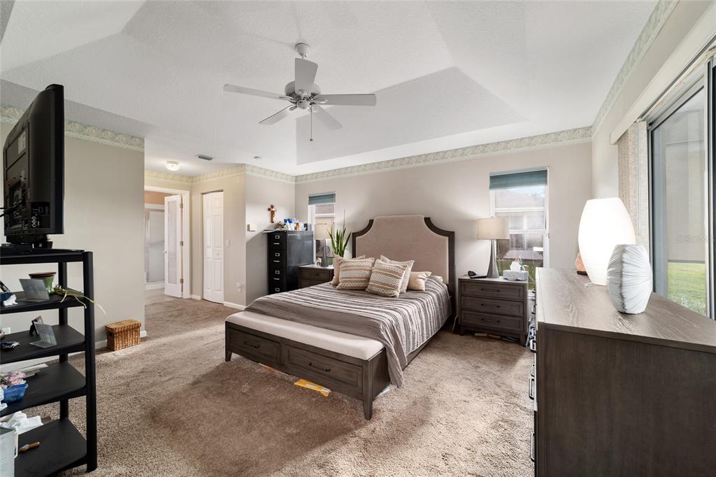 5245 Northwest 21st Loop Ocala, FL 34482 - Photo 13 of 26 a spacious bedroom with a bed a mirror and lamp