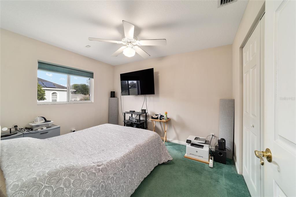 5245 Northwest 21st Loop Ocala, FL 34482 - Photo 17 of 26 a bedroom with a bed and a flat screen tv