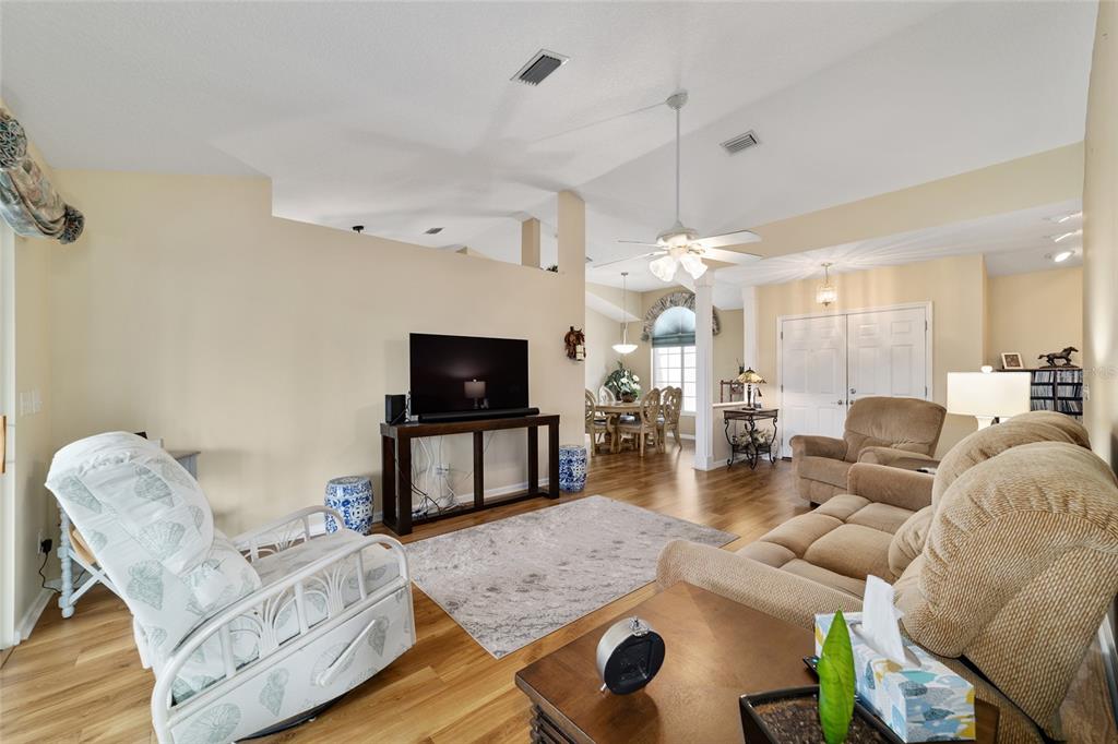 5245 Northwest 21st Loop Ocala, FL 34482 - Photo 7 of 26 a living room with furniture a flat screen tv and kitchen view