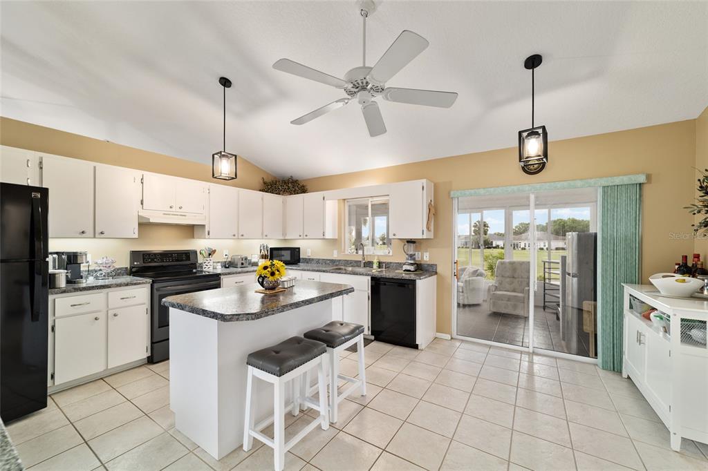 5245 Northwest 21st Loop Ocala, FL 34482 - Photo 10 of 26 a kitchen with refrigerator a stove and a chandelier