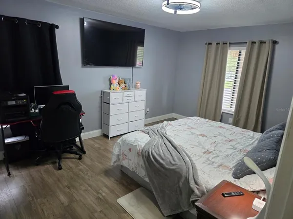 a bedroom with a bed and a flat screen tv