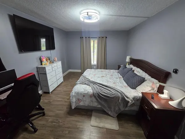 a bedroom with a bed and a flat screen tv