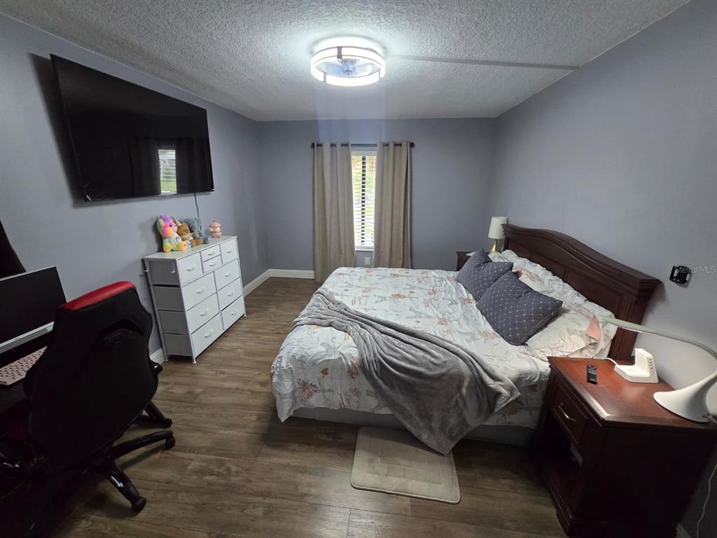 1624 South Pine Ridge Circle, Unit D2 Sanford, FL 32773 - Photo 7 of 14 a bedroom with a bed and a flat screen tv