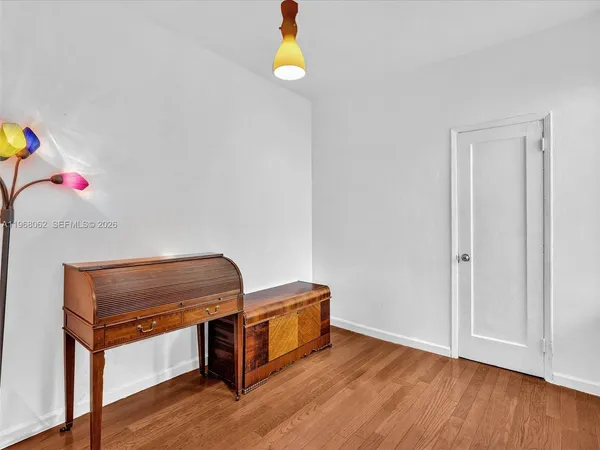 a view of a workspace with wooden floor and a window
