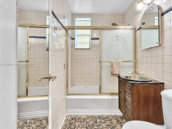 a bathroom with a granite countertop toilet sink and shower