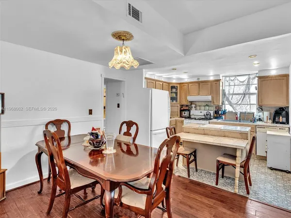 a kitchen with a refrigerator a stove a sink dishwasher with a dining table and chairs