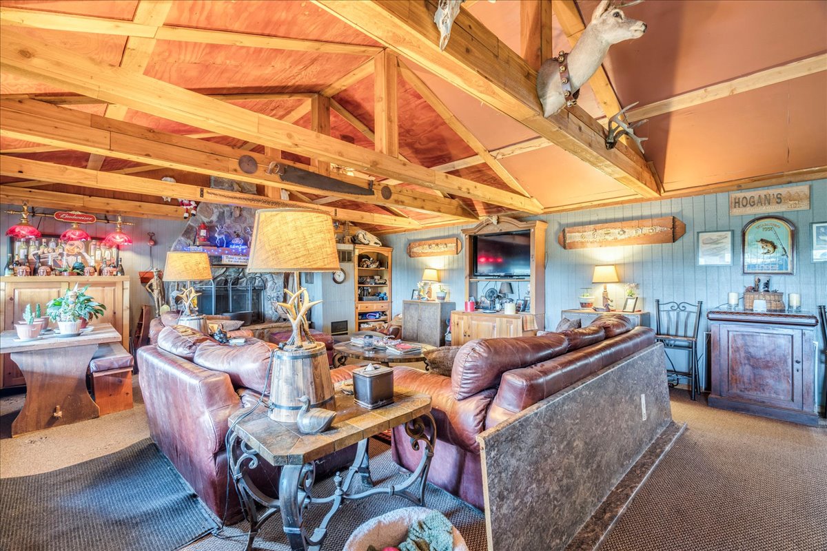 2411 Rohde Road Kyle, TX 78640 - Photo 20 of 40 Exposed wooden trusses and a stone fireplace anchor this rustic living area.