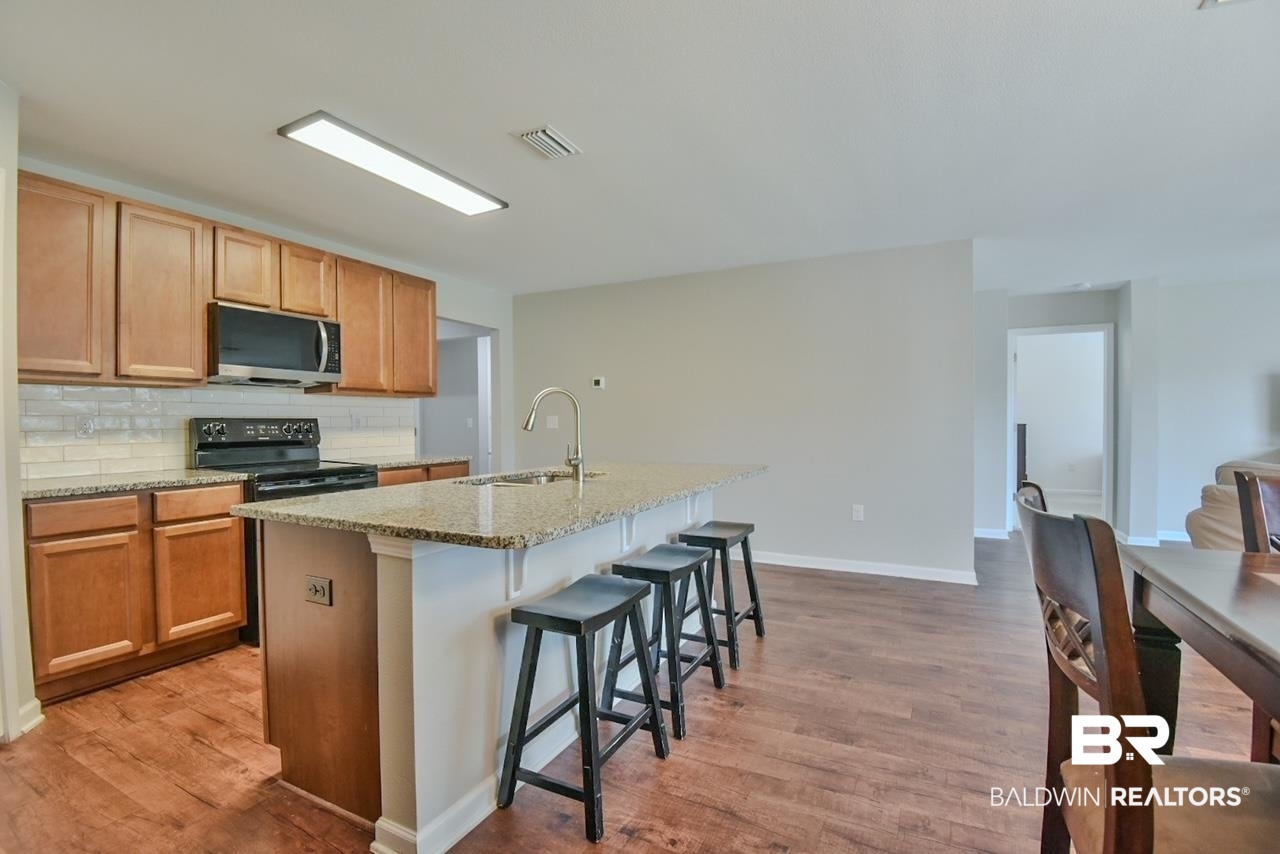 17430 Harding Drive Foley, AL 36535 - Photo 5 of 37 Kitchen featuring stainless steel microwave, a sink, light wood-type flooring, visible vents, and electric range