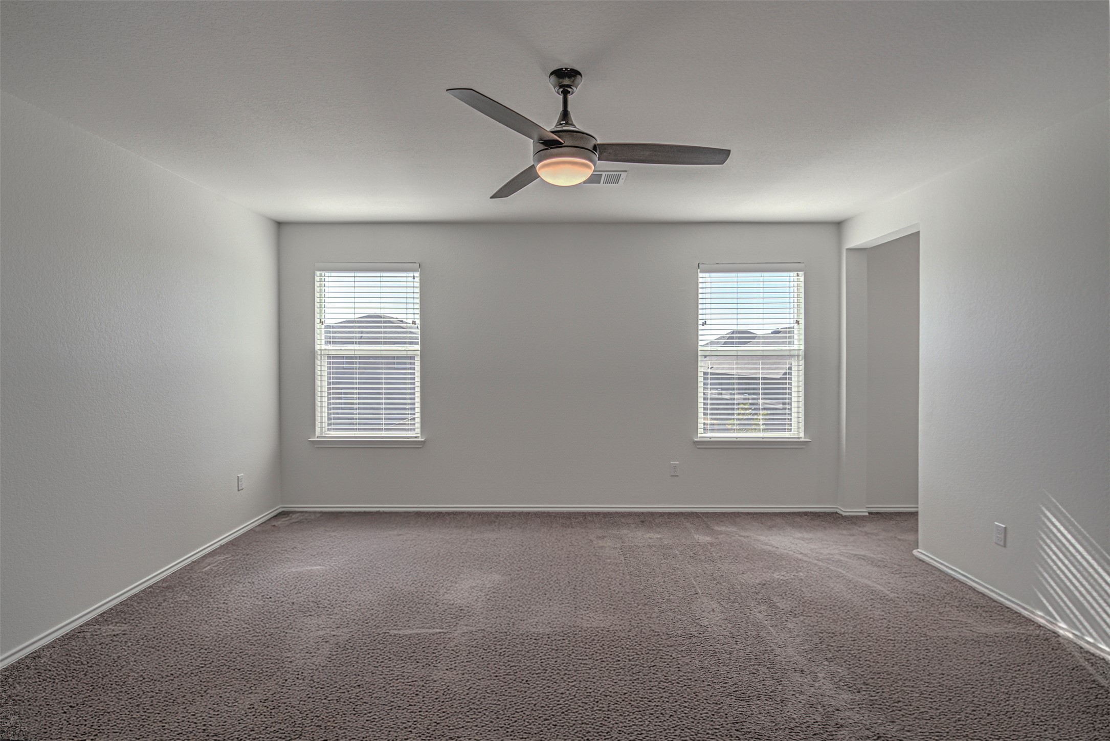 486 Gustaf Trail Kyle, TX 78640 - Photo 28 of 40 an empty room with a ceiling fan and windows