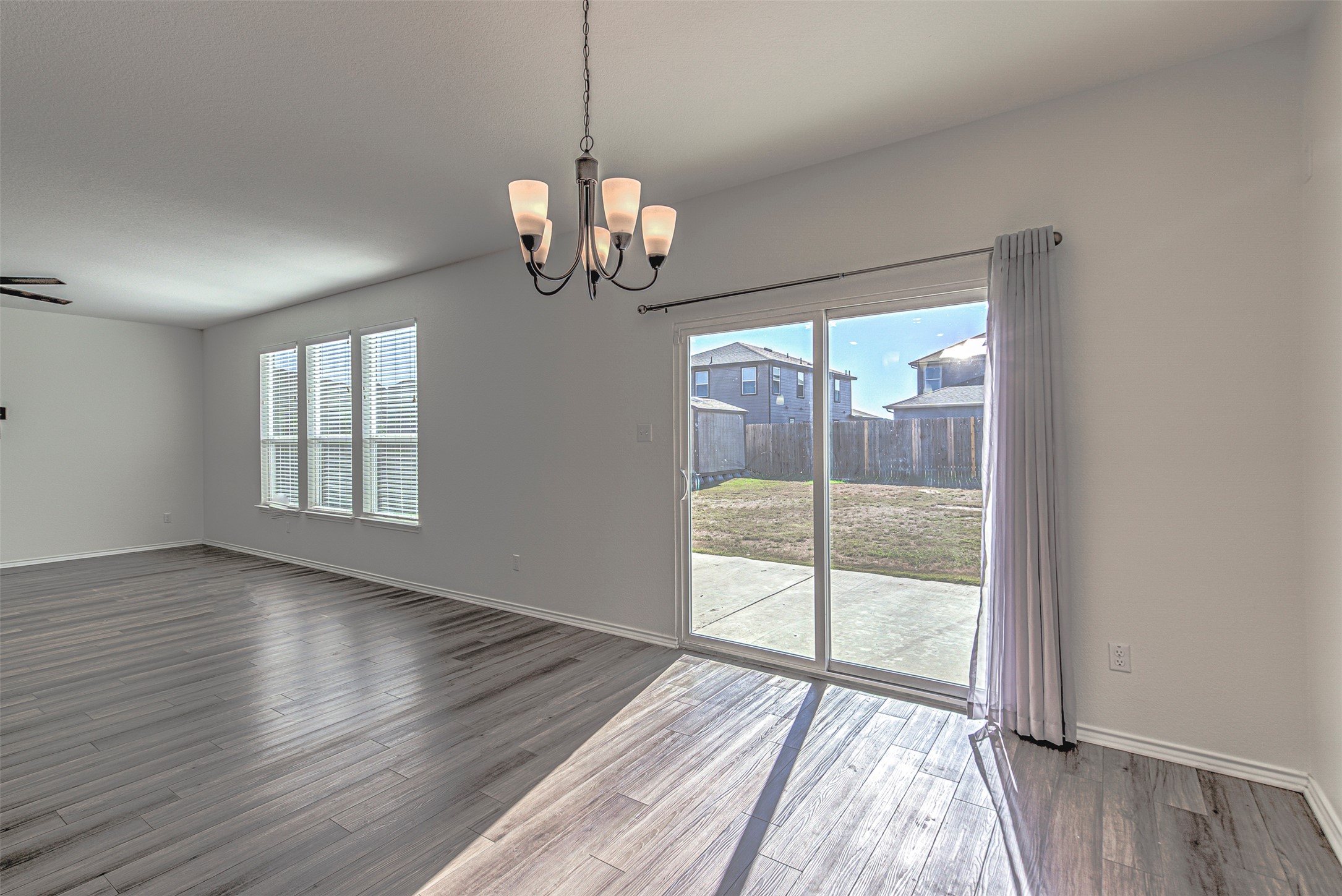 486 Gustaf Trail Kyle, TX 78640 - Photo 7 of 40 a view of an empty room with wooden floor and a window