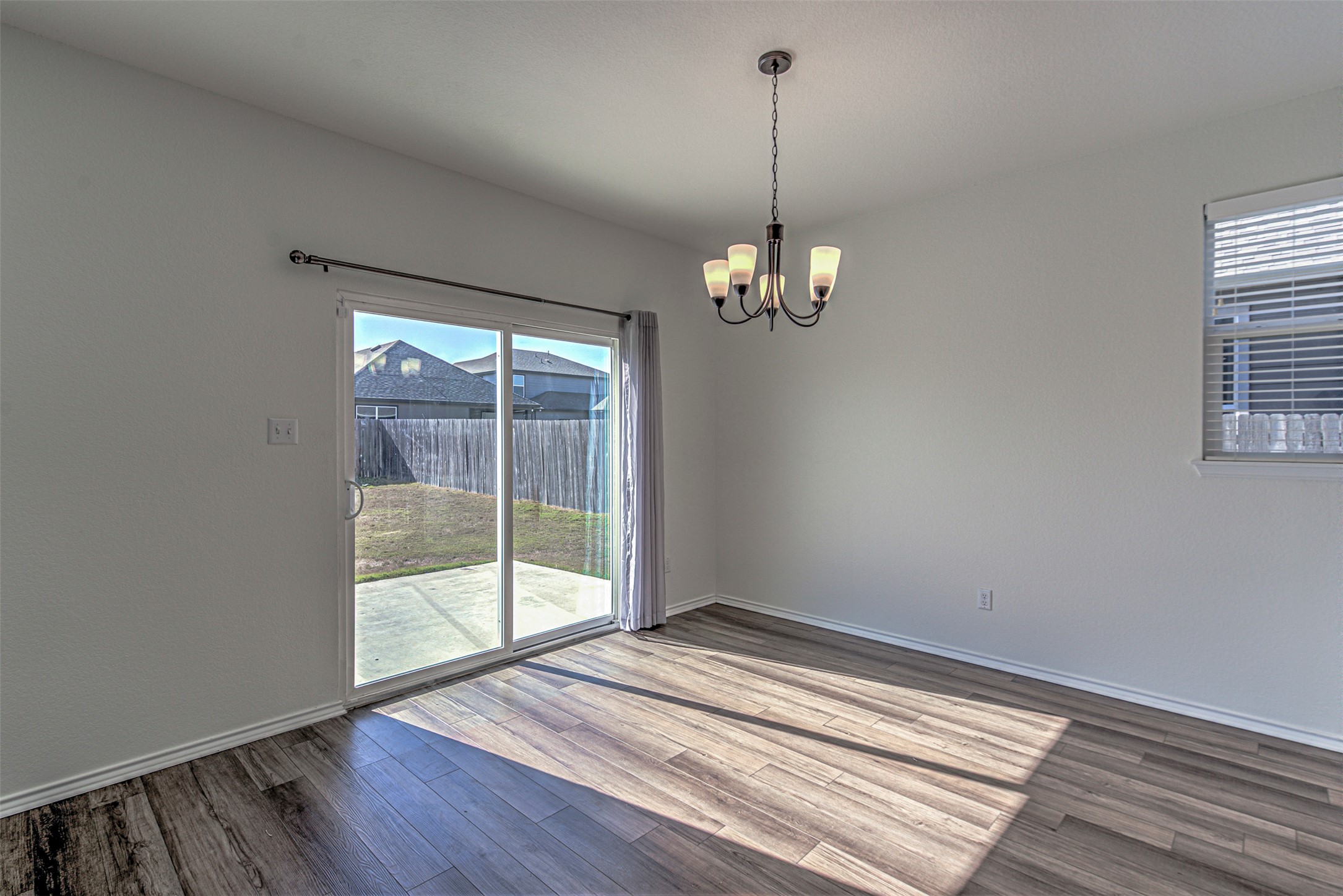 486 Gustaf Trail Kyle, TX 78640 - Photo 8 of 40 a view of empty room with wooden floor and fan