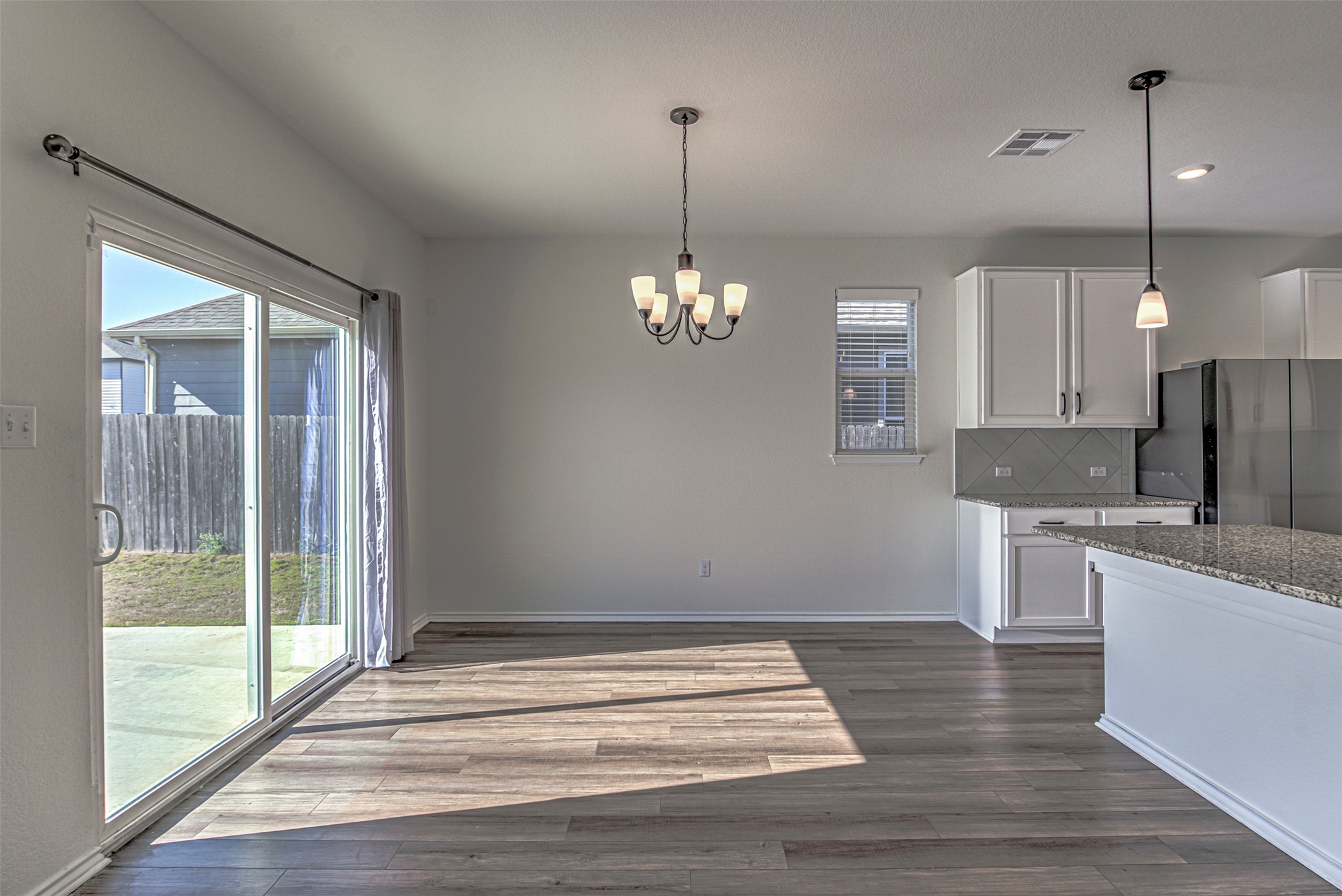 486 Gustaf Trail Kyle, TX 78640 - Photo 9 of 40 a view of a kitchen with a dishwasher cabinets and a wooden floor
