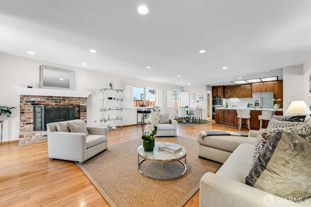 a kitchen with stainless steel appliances granite countertop a refrigerator a sink dishwasher a stove with wooden cabinets and floor