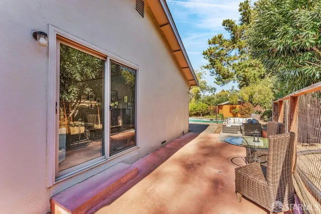 a view of a backyard with floor to ceiling window and wooden fence