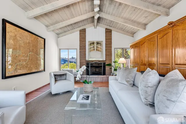 a living room with furniture a fireplace and a large window