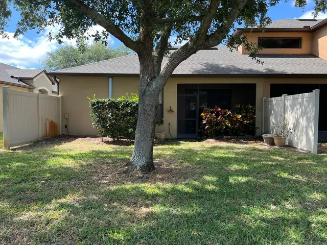 a view of a house with a yard and tree