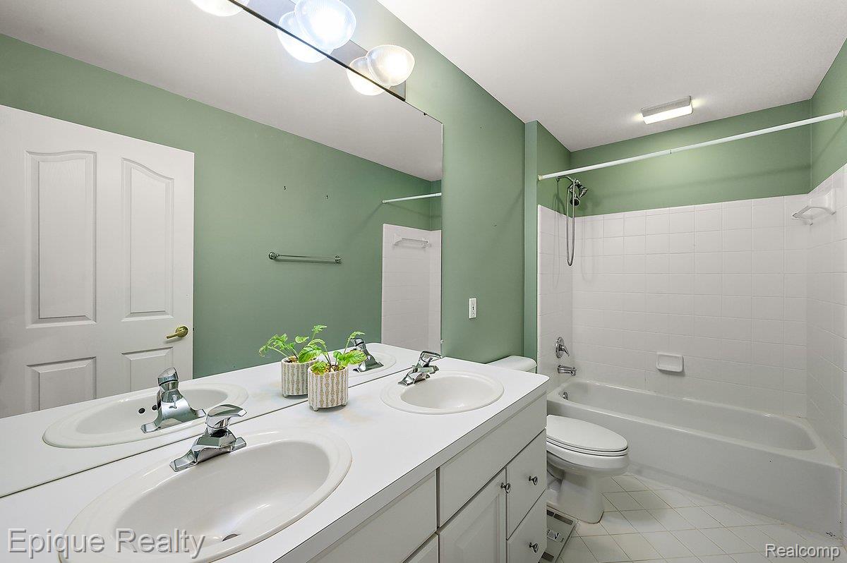 1909 Catlin Drive Rochester, MI 48306 - Photo 35 of 76 Bathroom featuring a double vanity with integrated sinks, a chrome faucet set, and a large wall-mounted mirror