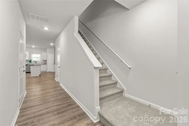 a view of a hallway with wooden floor and staircase
