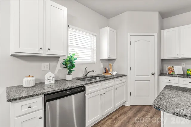 a kitchen with granite countertop white cabinets and white appliances