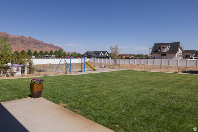 4635 East Sunny Acres Lane Moab, UT 84532 - Photo 24 of 56 Expansive grassy yard with mountain backdrop, concrete patio, and privacy fencing