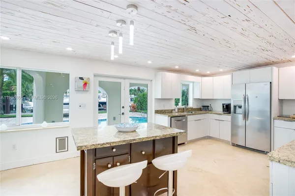 a kitchen with refrigerator cabinets dining table and chairs