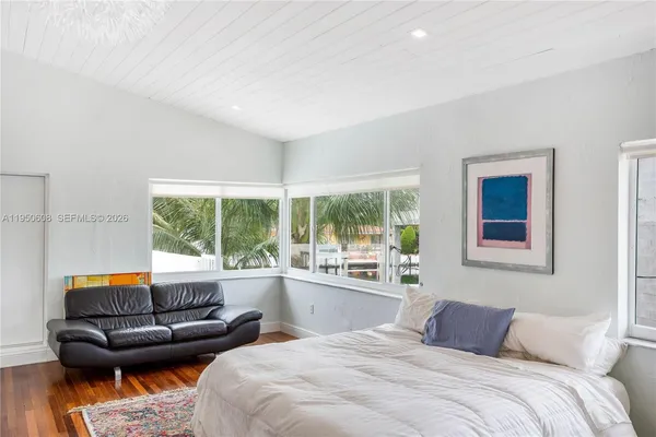 a bedroom with furniture and a large window