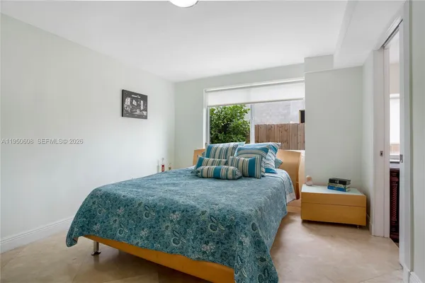 a bedroom with a bed and a large window