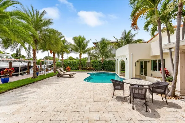 a view of a backyard with a patio and swimming pool