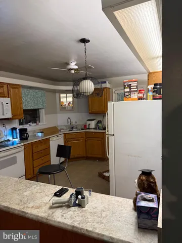 a kitchen with stainless steel appliances kitchen island granite countertop a sink dishwasher a stove and a refrigerator with wooden floor