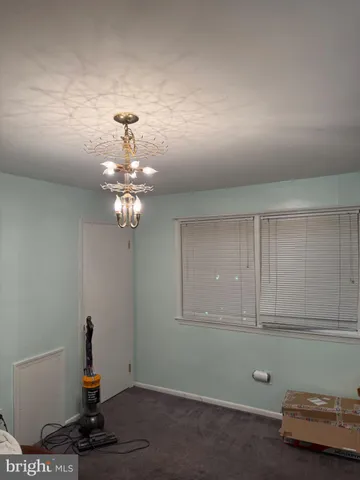 a room with a chandelier fan and a window