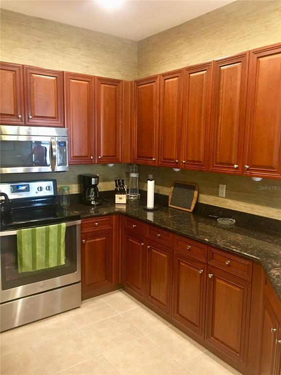 17084 Acapulco Road, Unit 223 Punta Gorda, FL 33955 - Photo 3 of 21 a kitchen with granite countertop a sink and cabinets