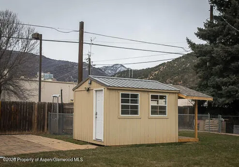 a view of a pool with two chairs in front of house