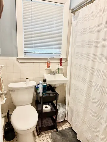 a bathroom with a sink a toilet and a window