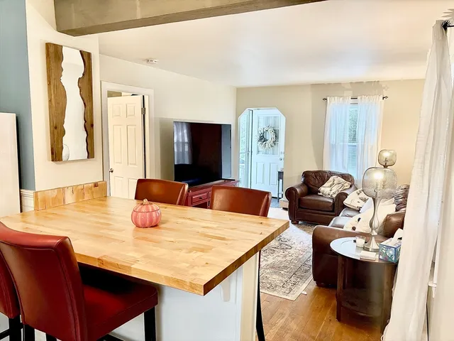 a living room with furniture a flat screen tv and a table