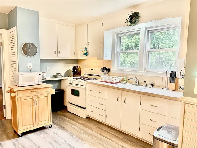 a kitchen with granite countertop white cabinets and white appliances