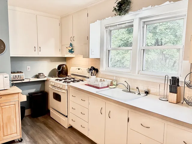 a kitchen with kitchen island granite countertop white cabinets white appliances and sink