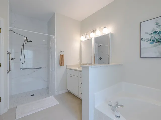 a bathroom with a tub sink shower and mirror