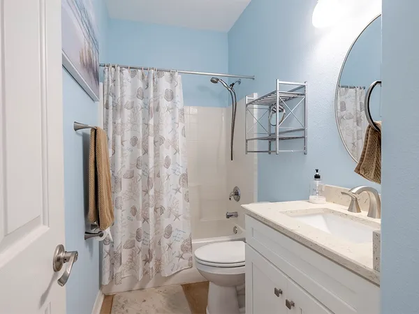 a bathroom with a granite countertop sink toilet and shower