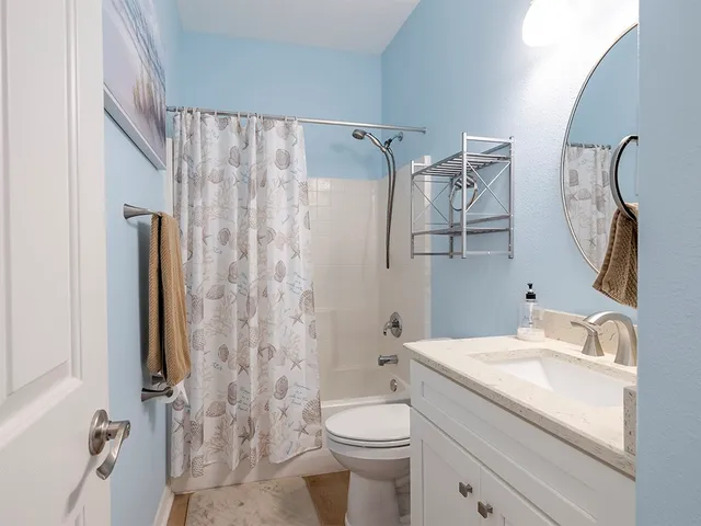 a bathroom with a granite countertop sink toilet and shower