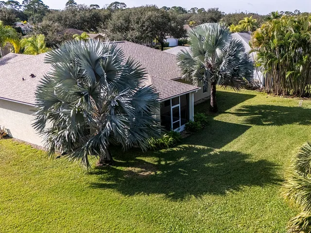 a view of a house with a yard and potted plants
